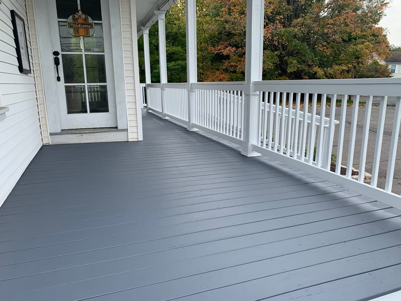 Gray painted porch with white railings and Welcome sign front view